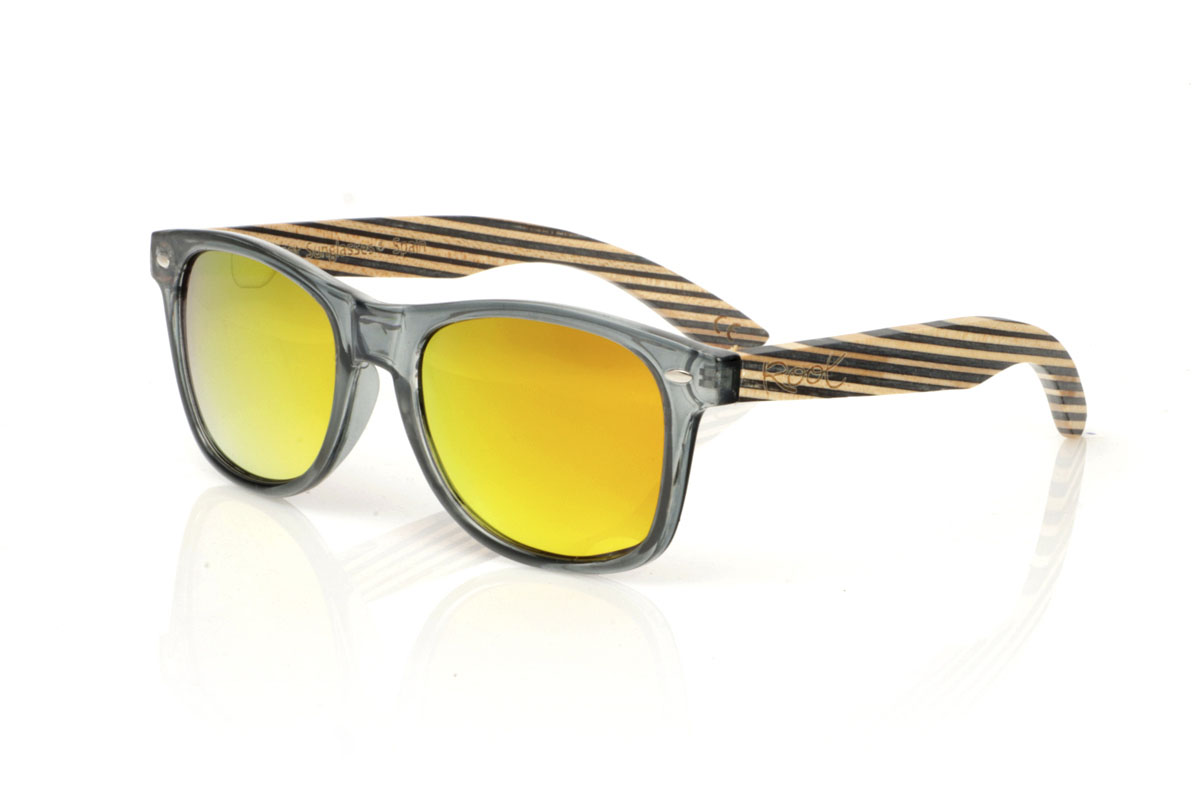 Gafas de Madera Natural de Arce SKA MIDNIGHT. Gafas de sol SKA MIDNIGHT, un giro moderno a los clásicos. Su montura en gris transparente brillo satinado captura esa vibra urbana que todos amamos, mientras que las varillas de madera de arce, estilo skateboards, muestran capas con tonos naturales y azul oscuro. Perfectas para quien valora la originalidad y la sostenibilidad en cada aspecto de su vida.  Las SKA MIDNIGHT no son solo gafas, son una declaración de principios. Medida frontal de 150x47 mm y calibre de 52. Venta al Por Mayor y Detalle | Root Sunglasses® 